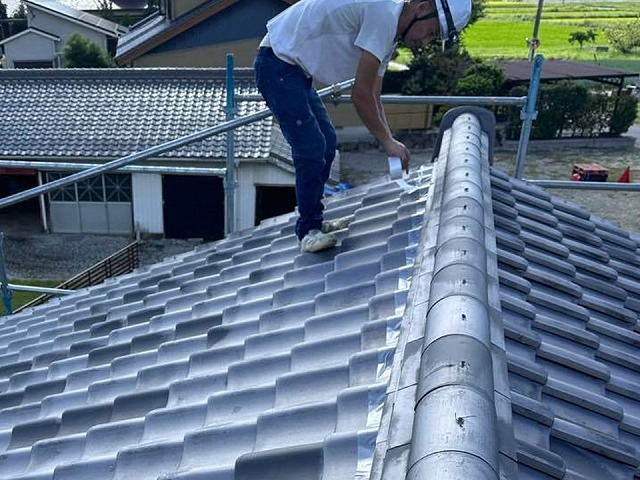 漆喰詰め直しメンテナンスで既存漆喰の除去前の養生を施す屋根職人