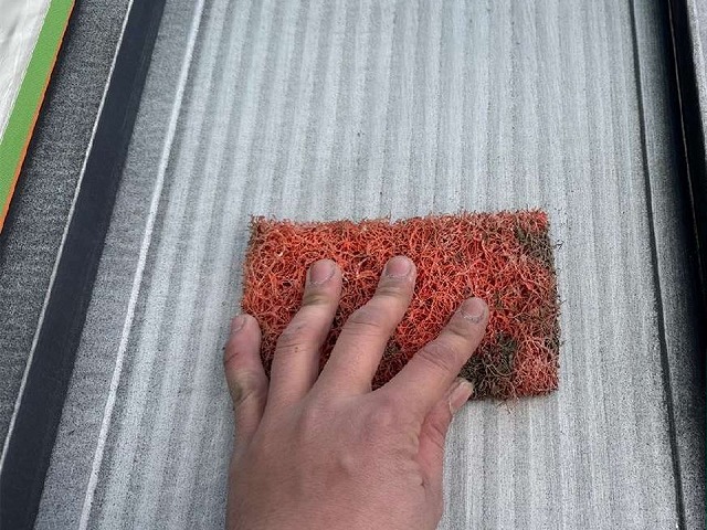 岡崎市の金属屋根塗り替え工事、ケレンによる下地処理や棟板金のビス締め直しの様子