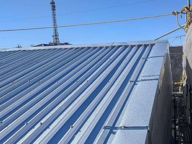 貸倉庫屋根カバー工事の棟部への板金役物設置工程