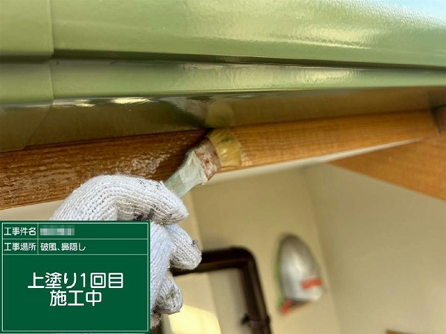 破風板や鼻隠しに塗料を丁寧に塗り込んでいる1回目塗装の施工の様子