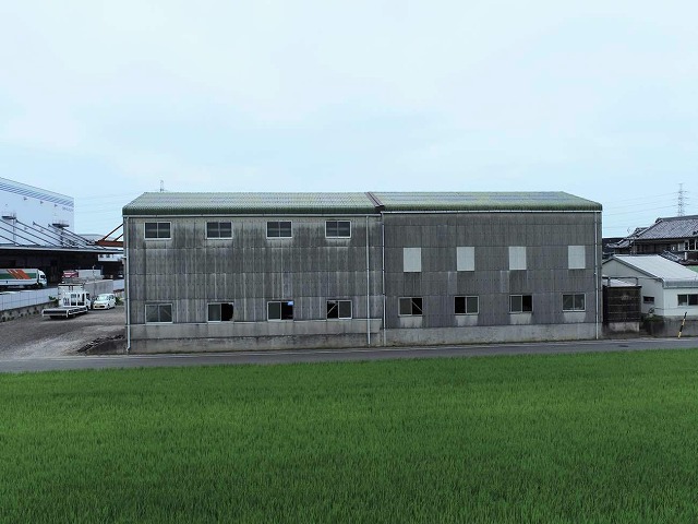 屋根カバー工事と外壁塗装メンテナンスを行う工場建物の外観