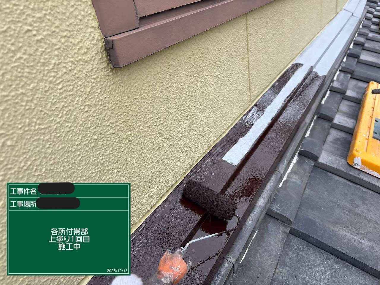 雨押え板金に1回目の上塗りを施工している様子
