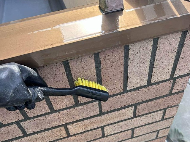 外壁タイル目地込み工事のブラシで表面を清掃している様子