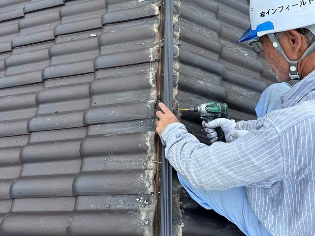 屋根棟瓦取り直し工事で受け金物に樹脂垂木をビス固定している様子