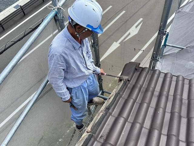 ケラバ部取り直し工事で既存袖瓦をバールを使って取り外している状況