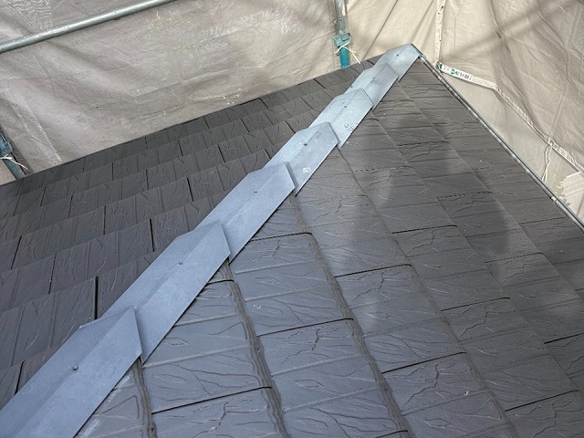 隅棟の差し棟板金に防水テープを貼り付けている施工の様子