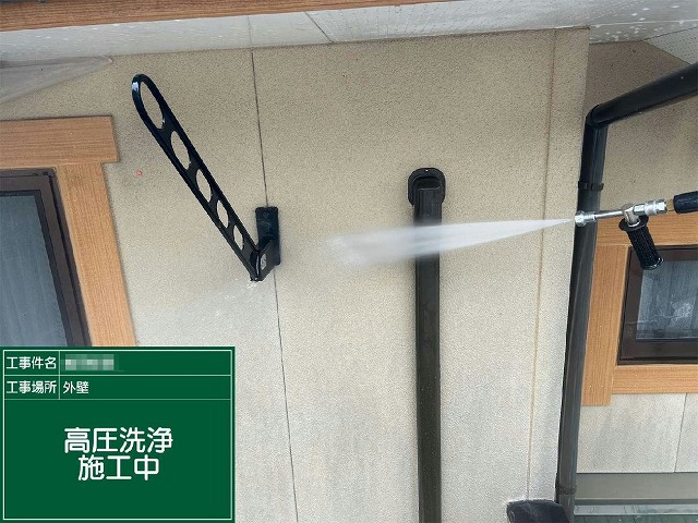 サイディング外壁に高圧洗浄を行い長年付着した汚れやカビを洗い落としている様子