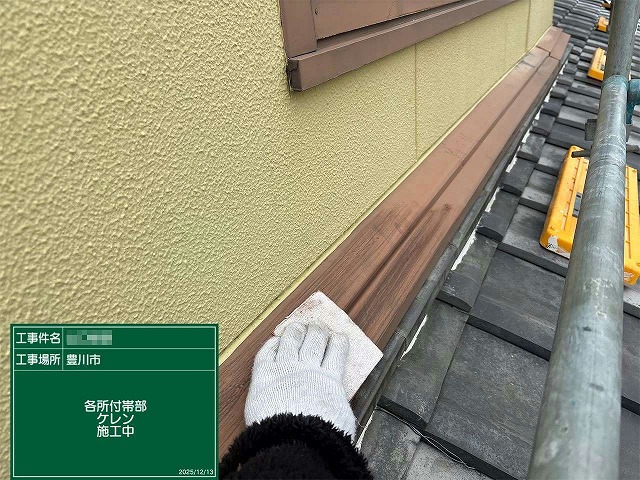 雨押え板金にサンドペーパーを当ててケレン作業を行っている様子