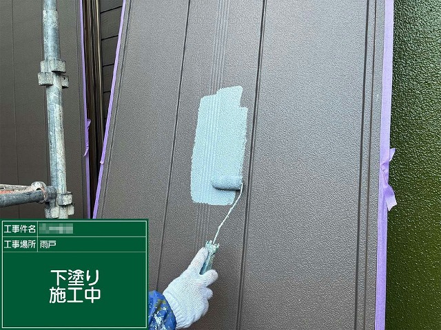 雨戸にローラーでサビ止め塗料による下塗りを行っている施工中の様子