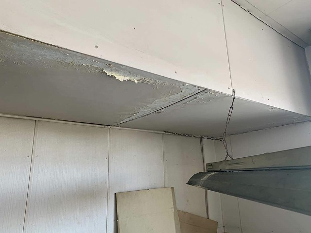 屋上防水の劣化による雨漏りで天井仕上げ材が剥がれている様子
