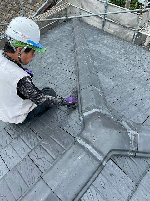 漆喰詰め直し工事後に濡れ雑巾で清掃を行う屋根職人