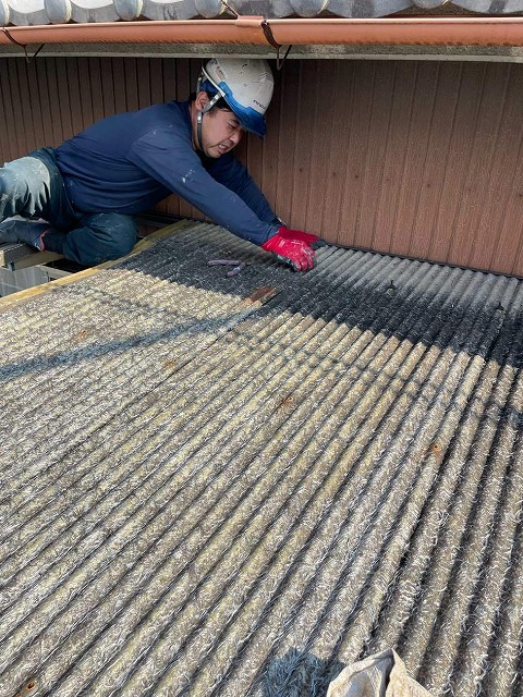ガラス繊維入り波板の撤去を行う屋根職人