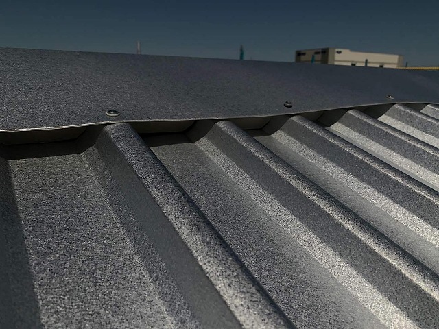 棟板金をガルバリウム鋼板屋根にビス固定している様子