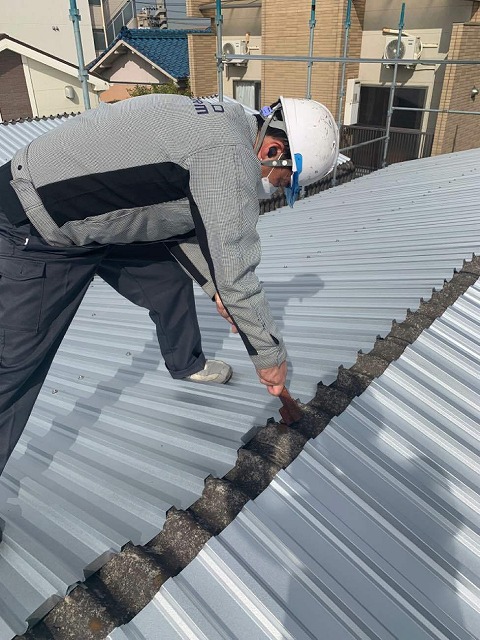 折板屋根の水上側で折り上げ加工を行う屋根職人