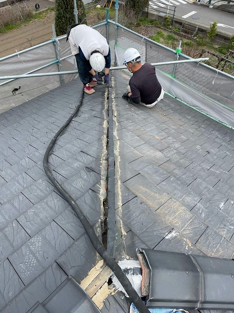棟瓦取り直し工事で樹脂製垂木を受け金具に固定する屋根職人
