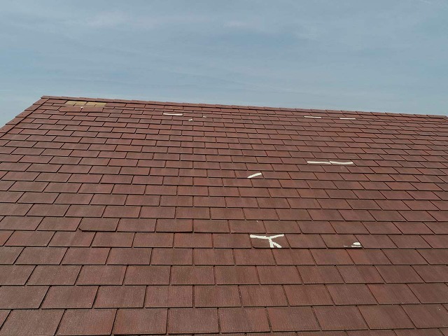 棟付近のスレート瓦のズレや補修跡が目立つ屋根