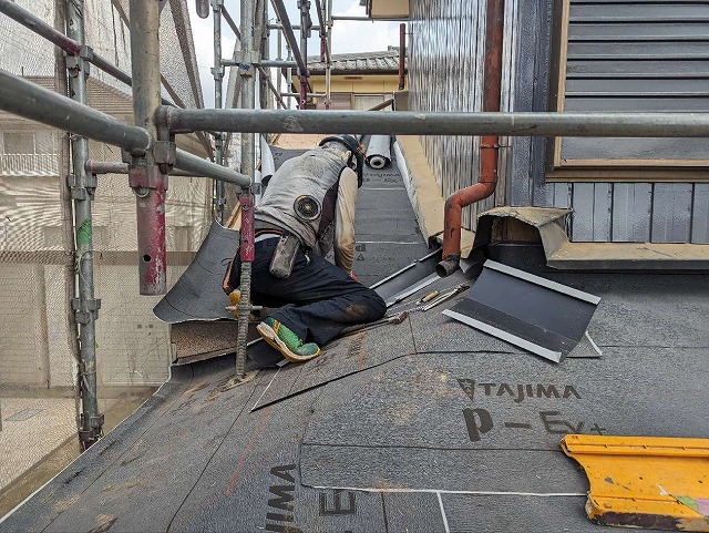 屋根葺き替え工事で谷板金を設置している屋根職人