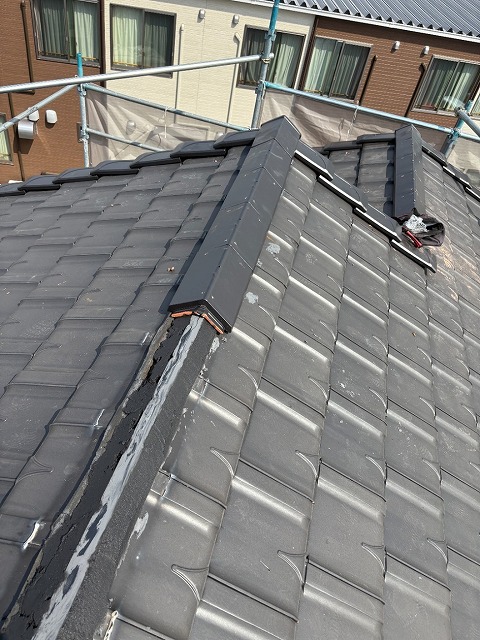 屋根役物取り替え改修工事で土台部分へ棟瓦を設置している様子