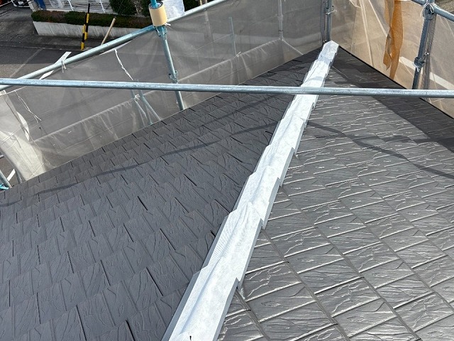 差し棟板金に防水テープを貼り付けながら施工を進めている状況
