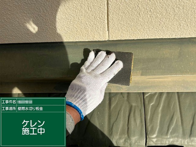 サンドペーパーで雨押え板金のサビや古い塗膜を削り落とすケレン作業の様子