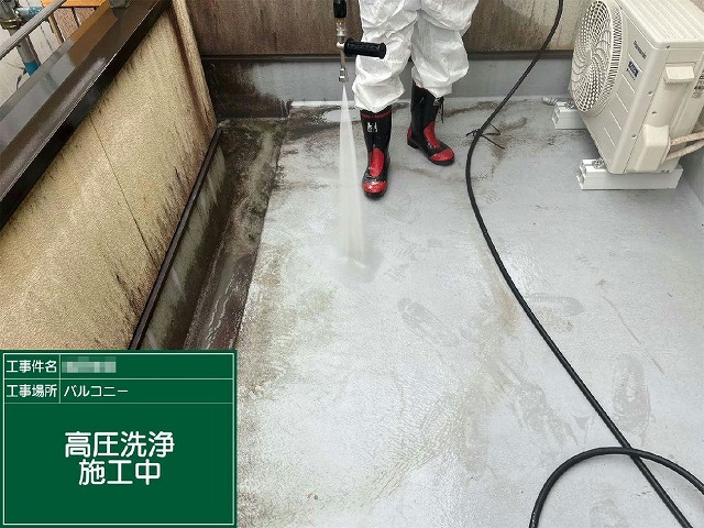 高圧洗浄機でベランダ床面の汚れを洗浄する様子