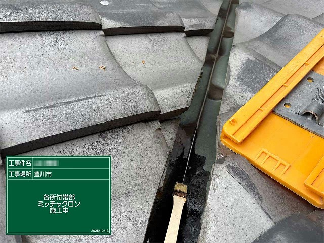 谷板金にサビ止め塗料を刷毛で塗布している様子