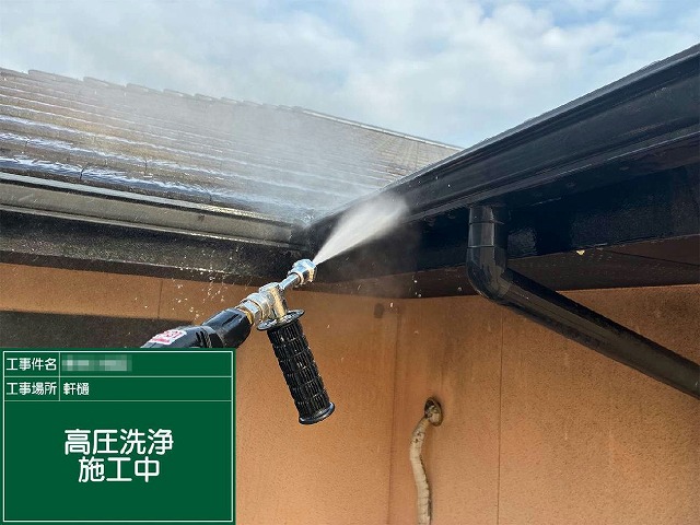 屋根際の軒樋（雨樋）に高圧洗浄を行っている様子