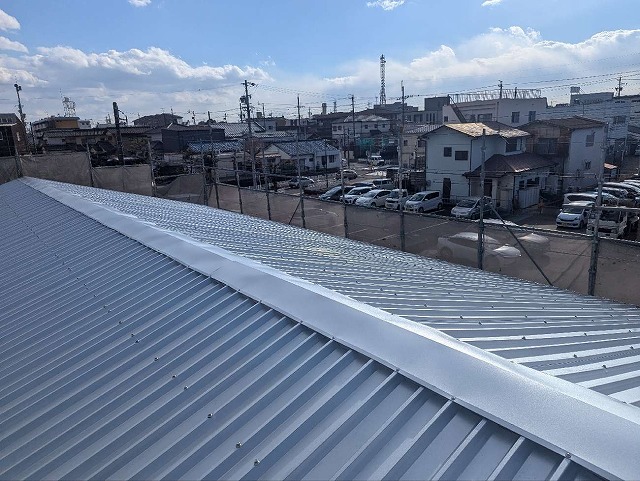 倉庫建物の劣化した波型スレートに対する折板屋根カバー工事が完了