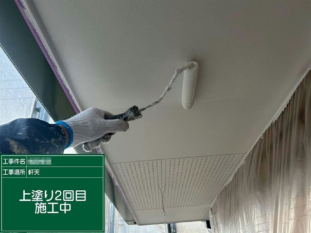 高圧洗浄後の軒天面に防カビ・防藻性塗料の2回目を塗布している施工の様子