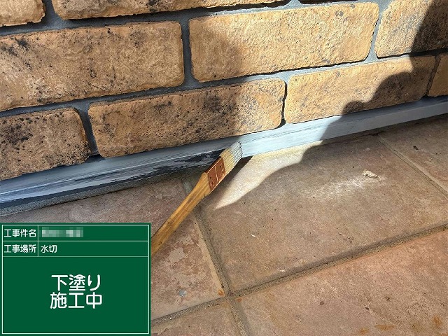 土台水切りに刷毛で下塗りを行っている施工中の様子