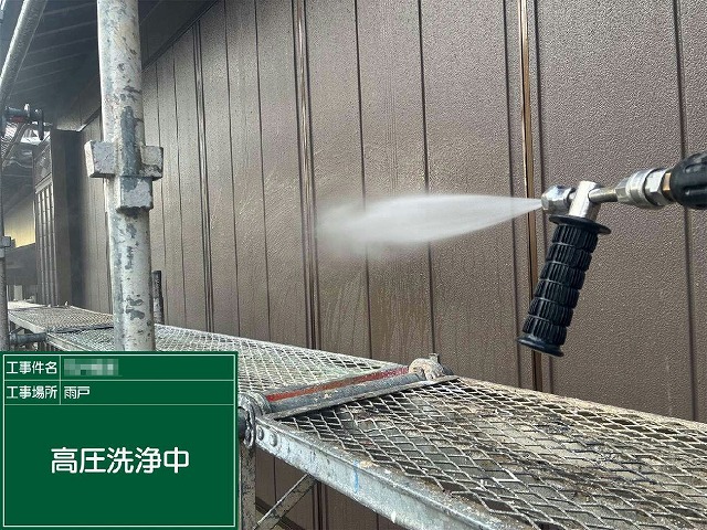 足場の上から付帯部の雨戸に高圧洗浄を行っている様子