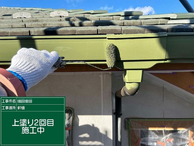 十分な乾燥時間を置いたうえで雨樋に2回目の塗料を重ね塗りしている施工の様子