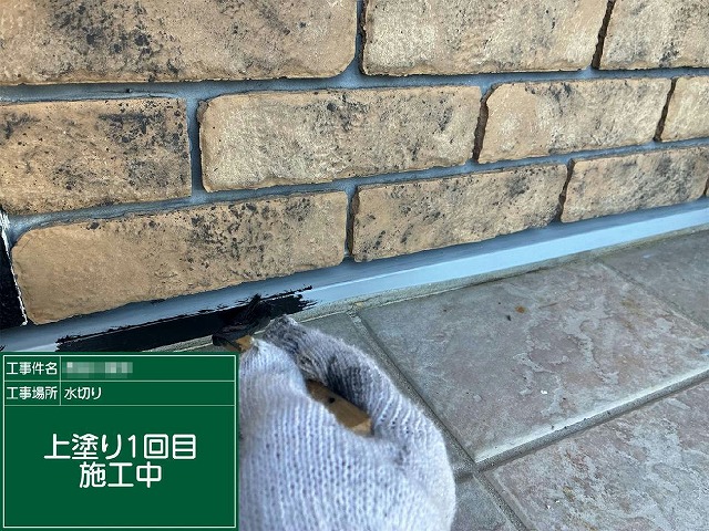 土台水切りに仕上げ用塗料で上塗り1回目を行っている様子