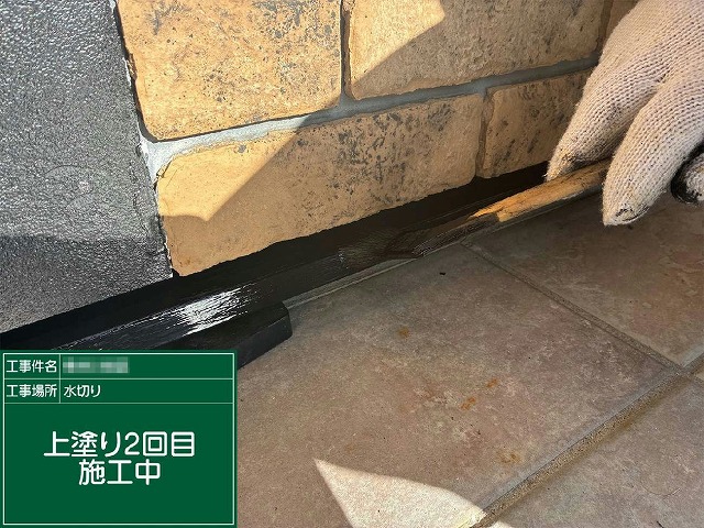 土台水切りに仕上げ用塗料で上塗り2回目を行っている様子
