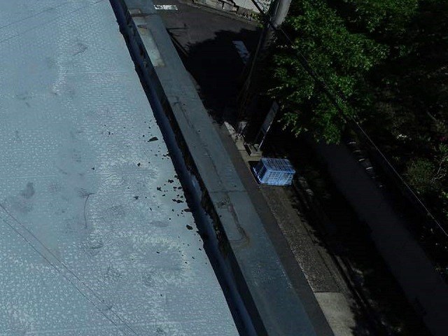 陸屋根住宅のパラペット笠木の塗膜が劣化して剥がれ落ちている様子