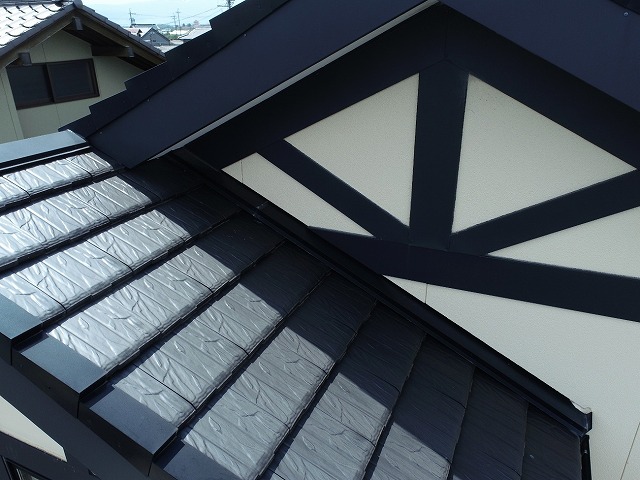 平板瓦に設置されている棟板金と同質役物との取り替えを行う住宅の外観