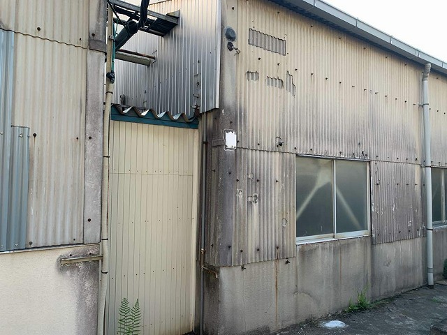 ガルバリウム鋼板製の金属サイディングでメンテナンスを行う工場建物の波型スレート外壁