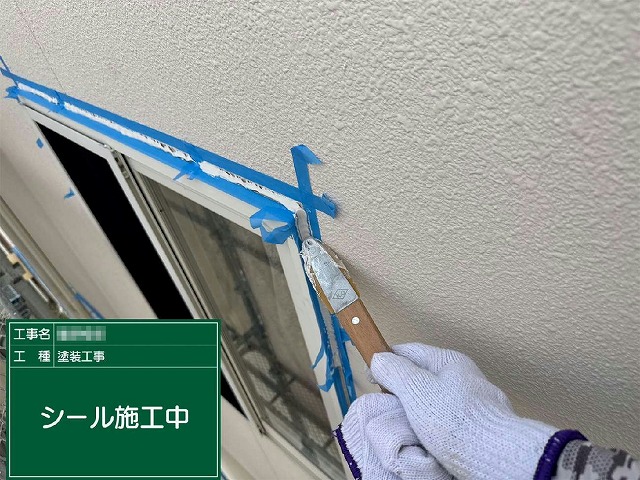 コーキング打ち替え工程のサッシまわりへのヘラ押さえ作業