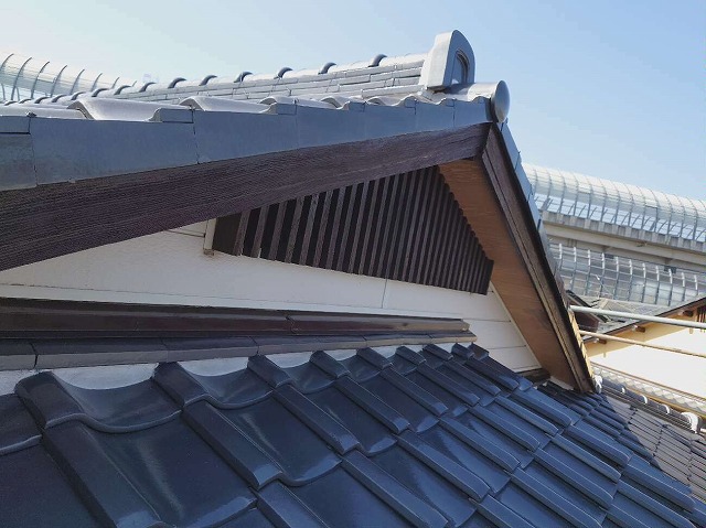 木製の破風板や雨押え板金への塗装と漆喰詰め直し工事が完了した住宅の屋根