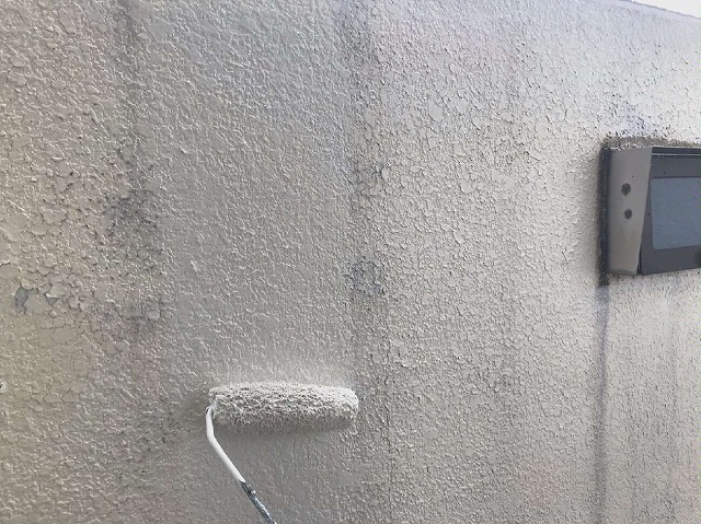 劣化した玄関前のブロック塀を塗装している様子