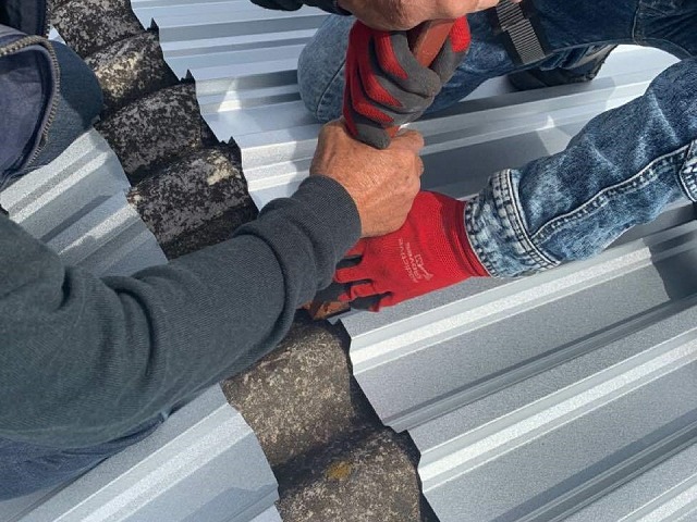 折板屋根の軒部分の折り上げ加工を行う屋根職人